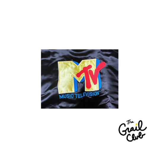 MTV logo patch on a black satin background with 'The Grail Club' branding.